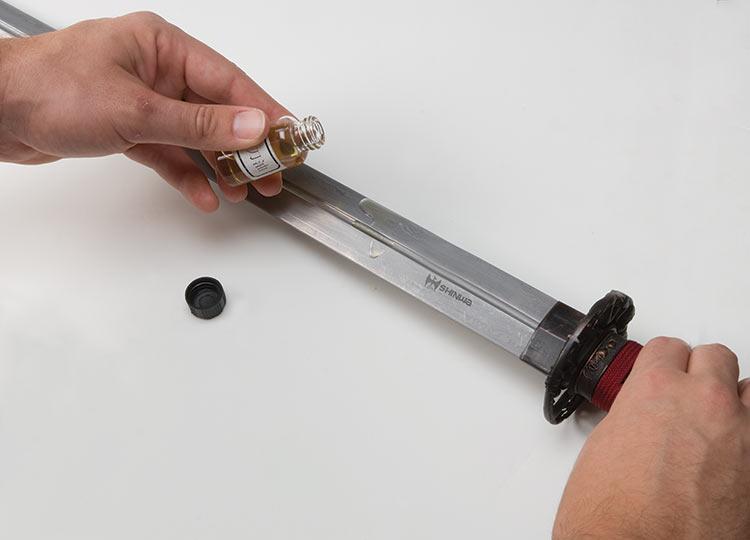 Applying choji oil to a Japanese katana blade using a soft cloth Applying choji oil to a Japanese katana blade using a soft cloth