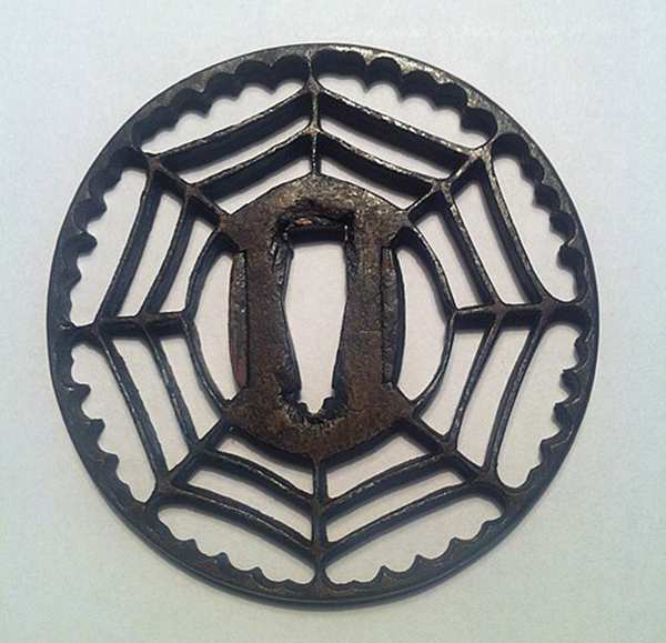 Traditional sukashi tsuba featuring an openwork design on a Japanese sword guard Traditional sukashi tsuba featuring an openwork design on a Japanese sword guard