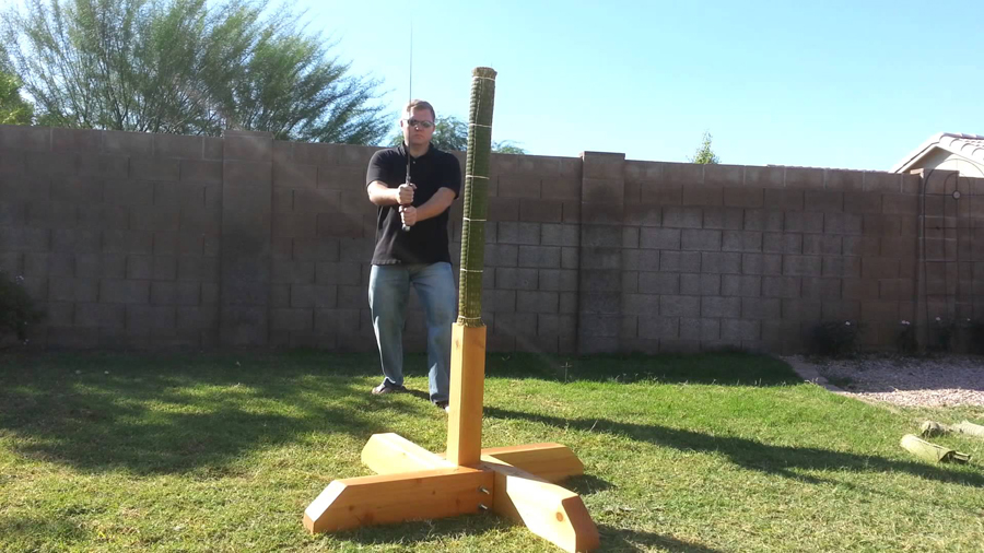 Japanese swordsman practicing tameshigiri on a rolled tatami omote cutting target