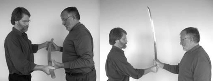 Two people carefully passing a sheathed Japanese katana using proper sword handling etiquette Two people carefully passing a sheathed Japanese katana using proper sword handling etiquette