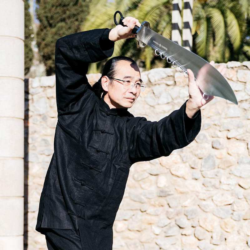 Martial artist demonstrating a nine ring broadsword with moving blade rings Martial artist demonstrating a nine ring broadsword with moving blade rings