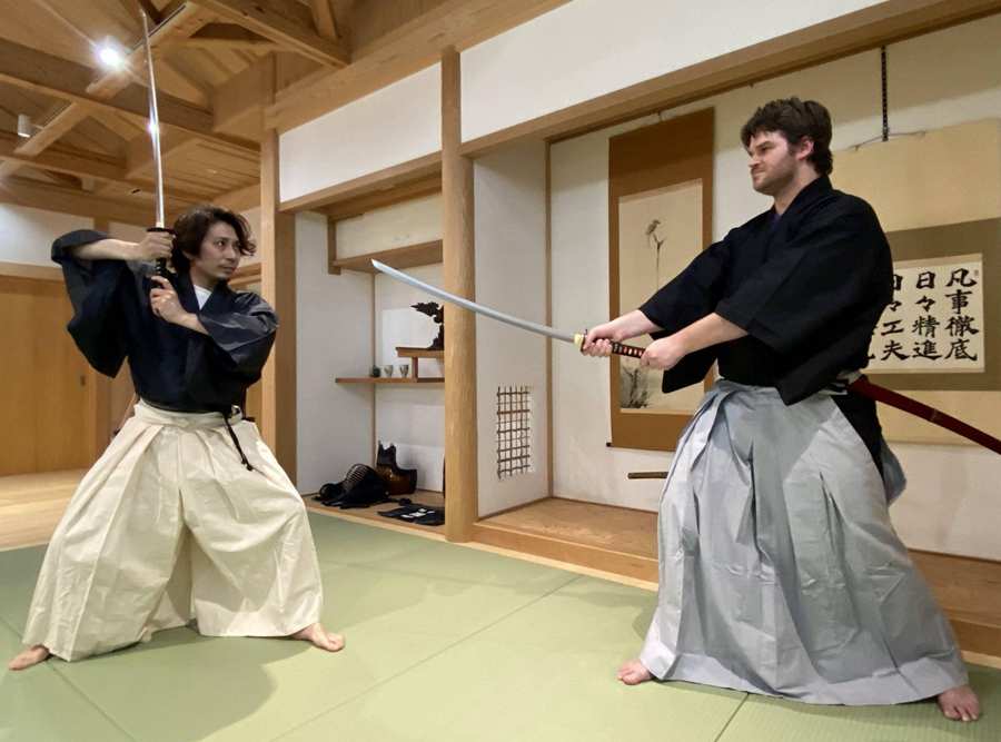 Japanese sword practitioner training katana techniques in dojo Japanese sword practitioner training katana techniques in dojo